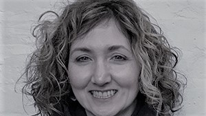 Black and white picture of woman with curly hair, smiling